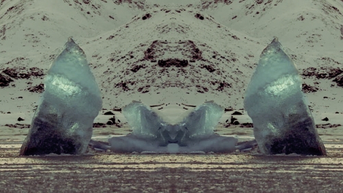 A still from one of  Iris' film. A symmetrical iceberg, rising from the water.