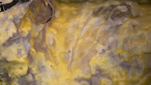 The image shows wax dripping in yellow splotches, an excerpt of the larger sculpture.