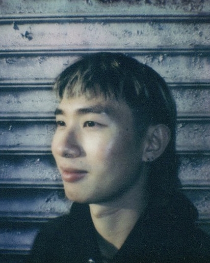 a photo of a male person (slightly long hair in his late 20s) facing sideways