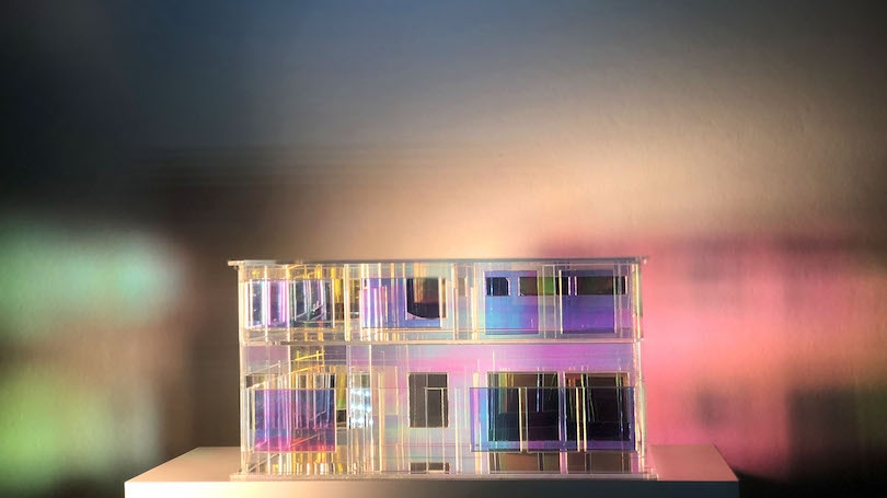 An acrylic model of the house Hahn grew up in bathed in different lights.