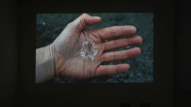 A still of a white hand with ice on the palm